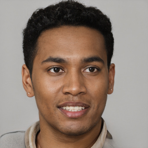 Joyful black young-adult male with short  black hair and brown eyes