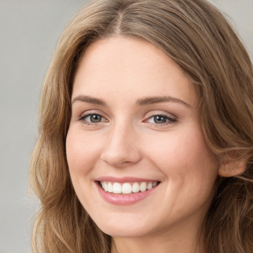 Joyful white young-adult female with long  brown hair and green eyes