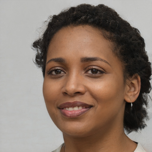 Joyful black young-adult female with medium  black hair and brown eyes