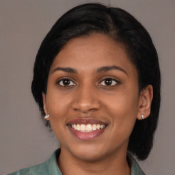 Joyful latino young-adult female with medium  black hair and brown eyes