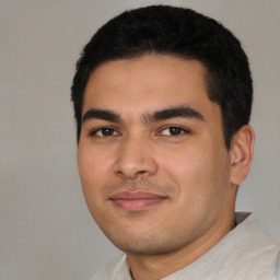 Joyful latino young-adult male with short  black hair and brown eyes
