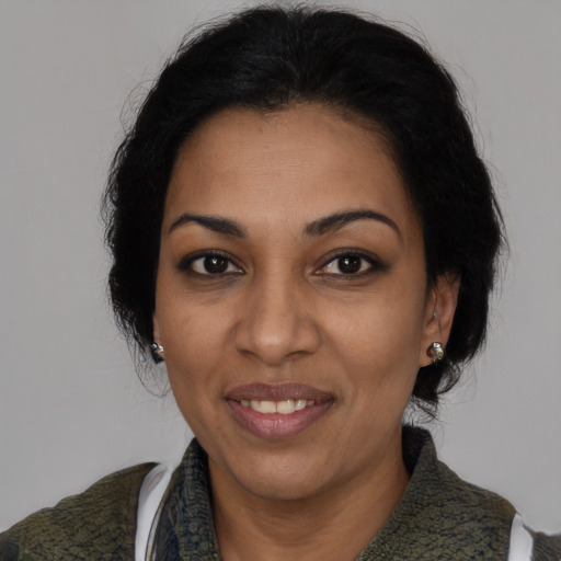 Joyful black adult female with medium  black hair and brown eyes