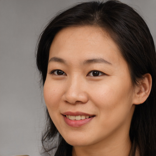 Joyful asian young-adult female with long  brown hair and brown eyes