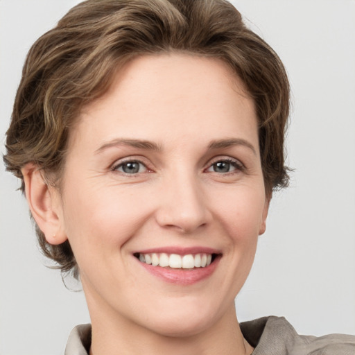 Joyful white young-adult female with short  brown hair and grey eyes