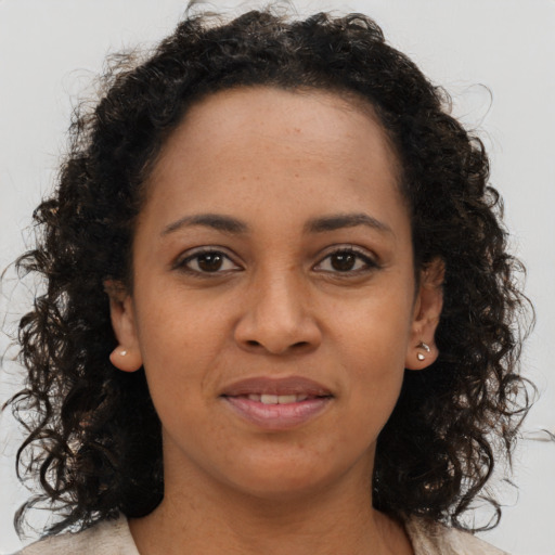 Joyful black young-adult female with long  brown hair and brown eyes