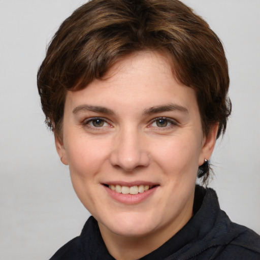 Joyful white young-adult female with medium  brown hair and grey eyes