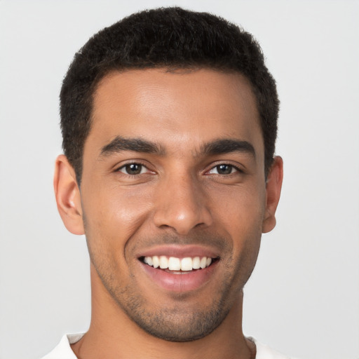 Joyful latino young-adult male with short  brown hair and brown eyes