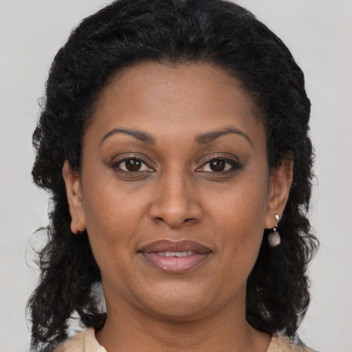 Joyful black adult female with long  brown hair and brown eyes