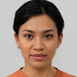 Joyful latino young-adult female with short  black hair and brown eyes