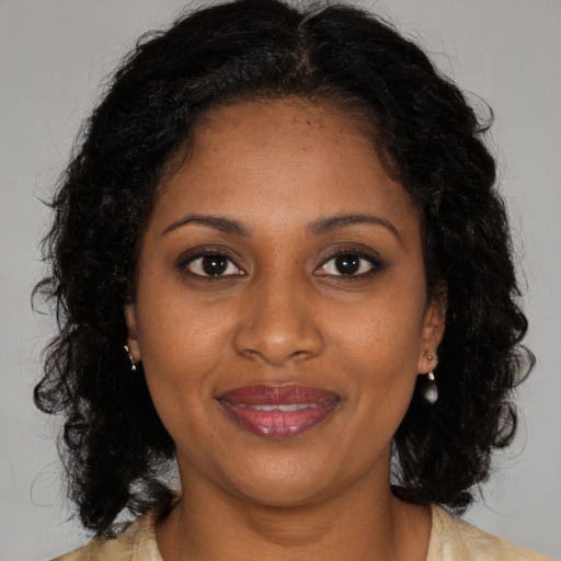 Joyful black adult female with medium  brown hair and brown eyes