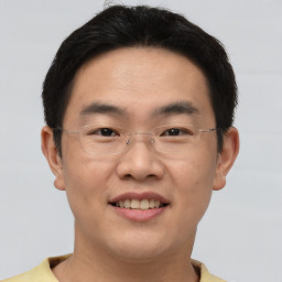 Joyful asian young-adult male with short  brown hair and brown eyes