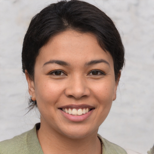 Joyful latino young-adult female with short  brown hair and brown eyes