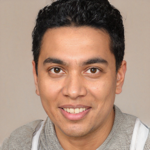 Joyful white young-adult male with short  black hair and brown eyes