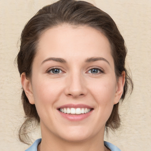 Joyful white young-adult female with medium  brown hair and grey eyes