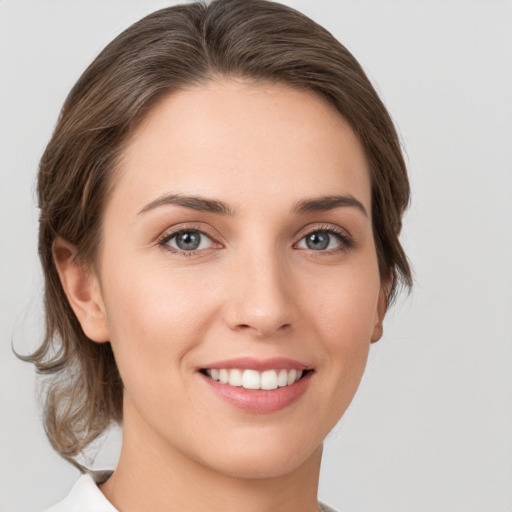 Joyful white young-adult female with medium  brown hair and green eyes