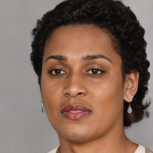 Joyful black young-adult female with short  brown hair and brown eyes