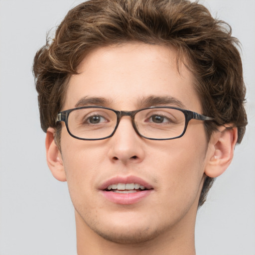 Joyful white young-adult male with short  brown hair and green eyes