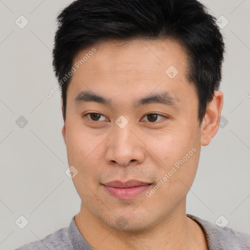 Joyful asian young-adult male with short  black hair and brown eyes