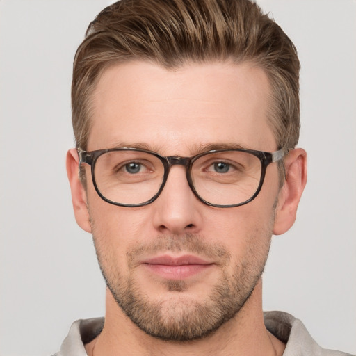 Joyful white young-adult male with short  brown hair and grey eyes