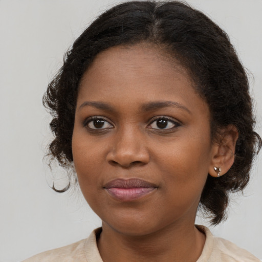 Joyful black young-adult female with medium  brown hair and brown eyes