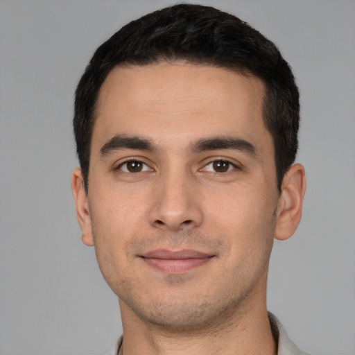 Joyful white young-adult male with short  black hair and brown eyes