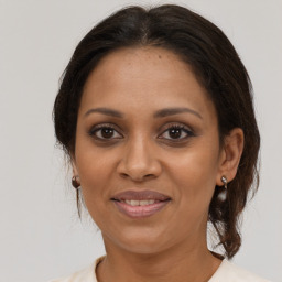 Joyful black adult female with medium  brown hair and brown eyes