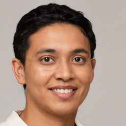 Joyful latino young-adult male with short  brown hair and brown eyes