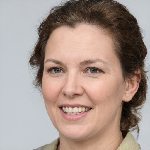 Joyful white adult female with medium  brown hair and grey eyes