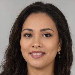 Joyful latino young-adult female with long  brown hair and brown eyes