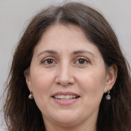 Joyful white adult female with long  brown hair and grey eyes