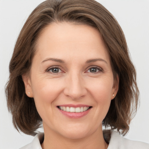 Joyful white adult female with medium  brown hair and brown eyes