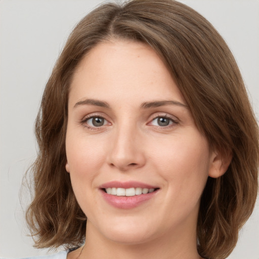 Joyful white young-adult female with medium  brown hair and green eyes