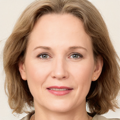 Joyful white adult female with medium  brown hair and grey eyes