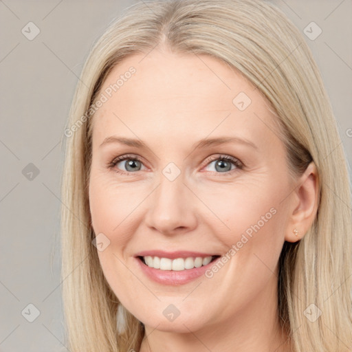 Joyful white adult female with long  brown hair and blue eyes