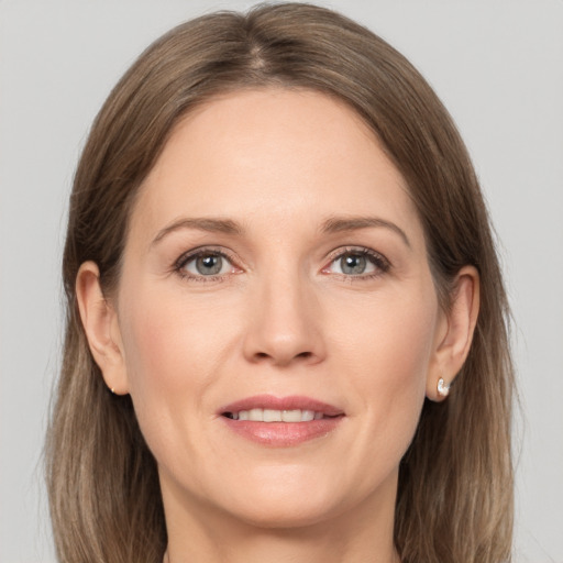 Joyful white adult female with long  brown hair and grey eyes