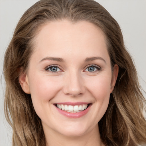 Joyful white young-adult female with long  brown hair and grey eyes