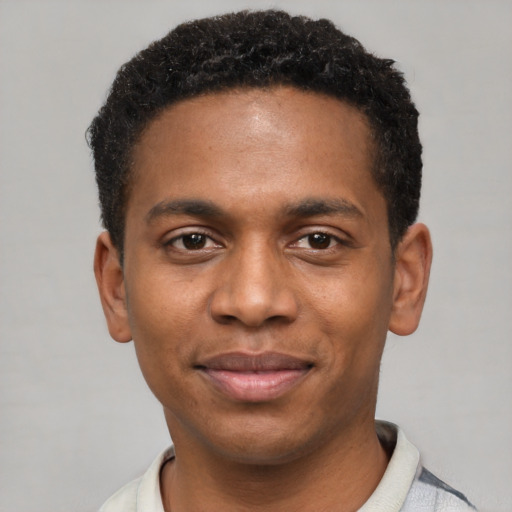 Joyful black young-adult male with short  black hair and brown eyes