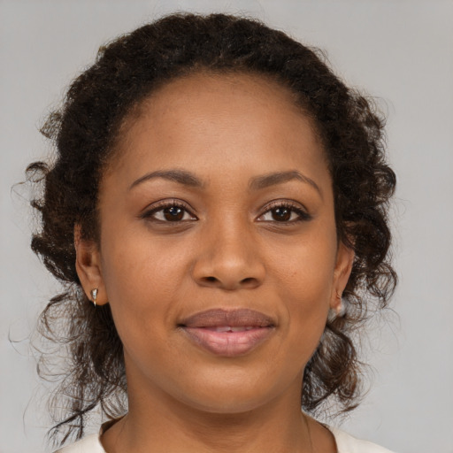 Joyful black adult female with medium  brown hair and brown eyes
