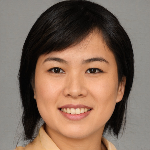 Joyful asian young-adult female with medium  brown hair and brown eyes