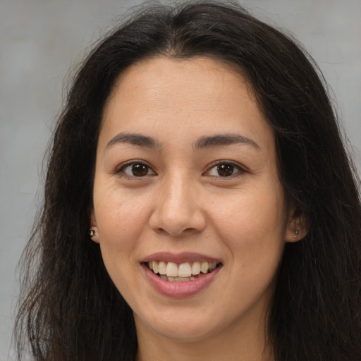 Joyful latino young-adult female with long  brown hair and brown eyes