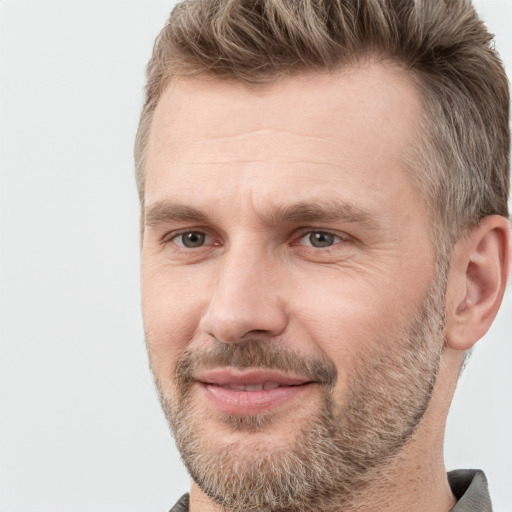 Joyful white adult male with short  brown hair and grey eyes