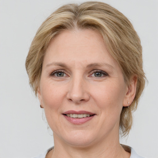 Joyful white adult female with medium  brown hair and grey eyes