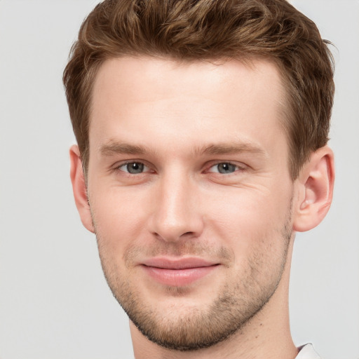 Joyful white young-adult male with short  brown hair and grey eyes