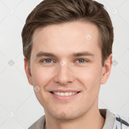 Joyful white young-adult male with short  brown hair and grey eyes