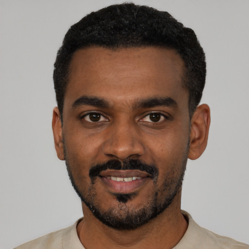 Joyful black young-adult male with short  black hair and brown eyes