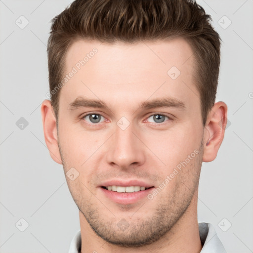 Joyful white young-adult male with short  brown hair and grey eyes