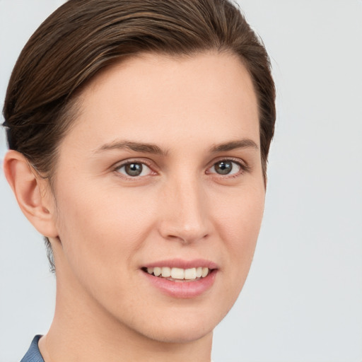 Joyful white young-adult female with medium  brown hair and grey eyes