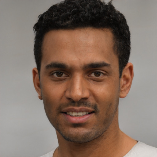Joyful latino young-adult male with short  black hair and brown eyes