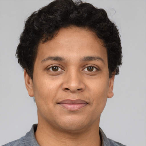 Joyful latino young-adult male with short  brown hair and brown eyes