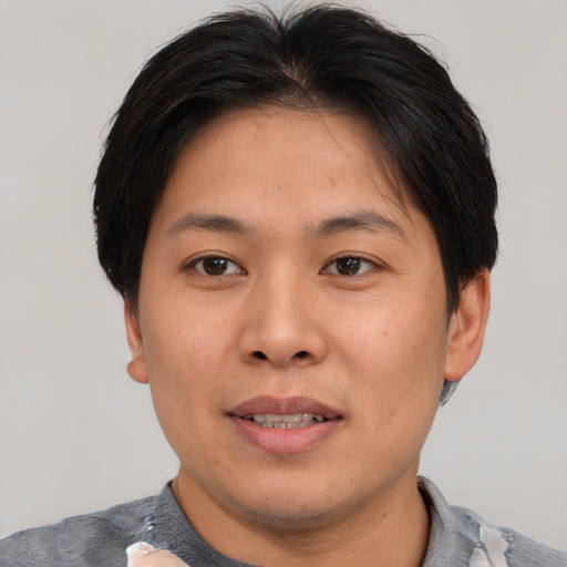 Joyful asian adult male with short  brown hair and brown eyes